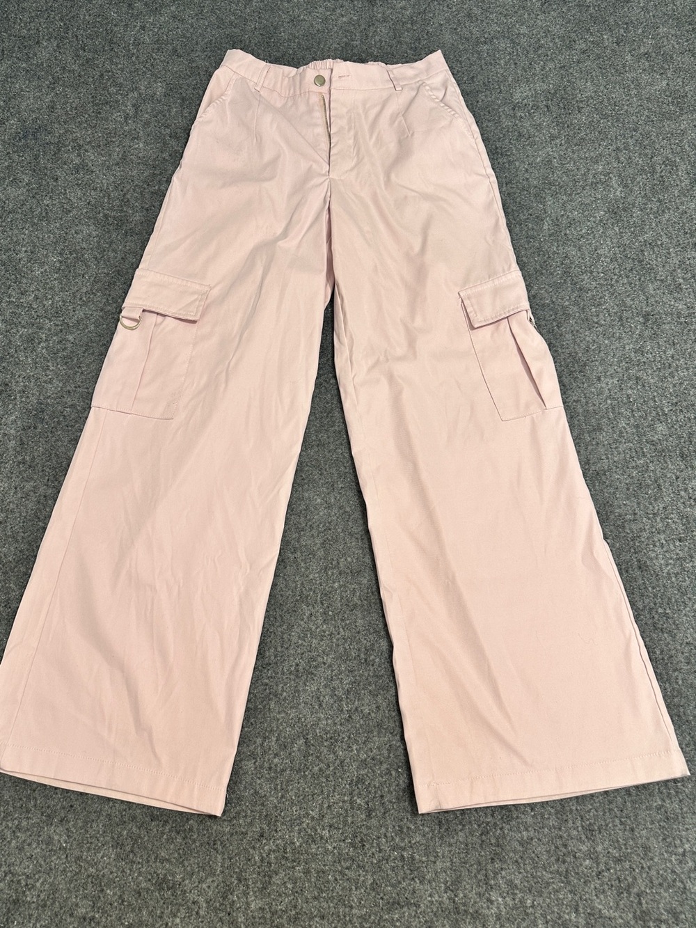 Light pink, low-slung straight cargo pants with utility pockets on the sides.